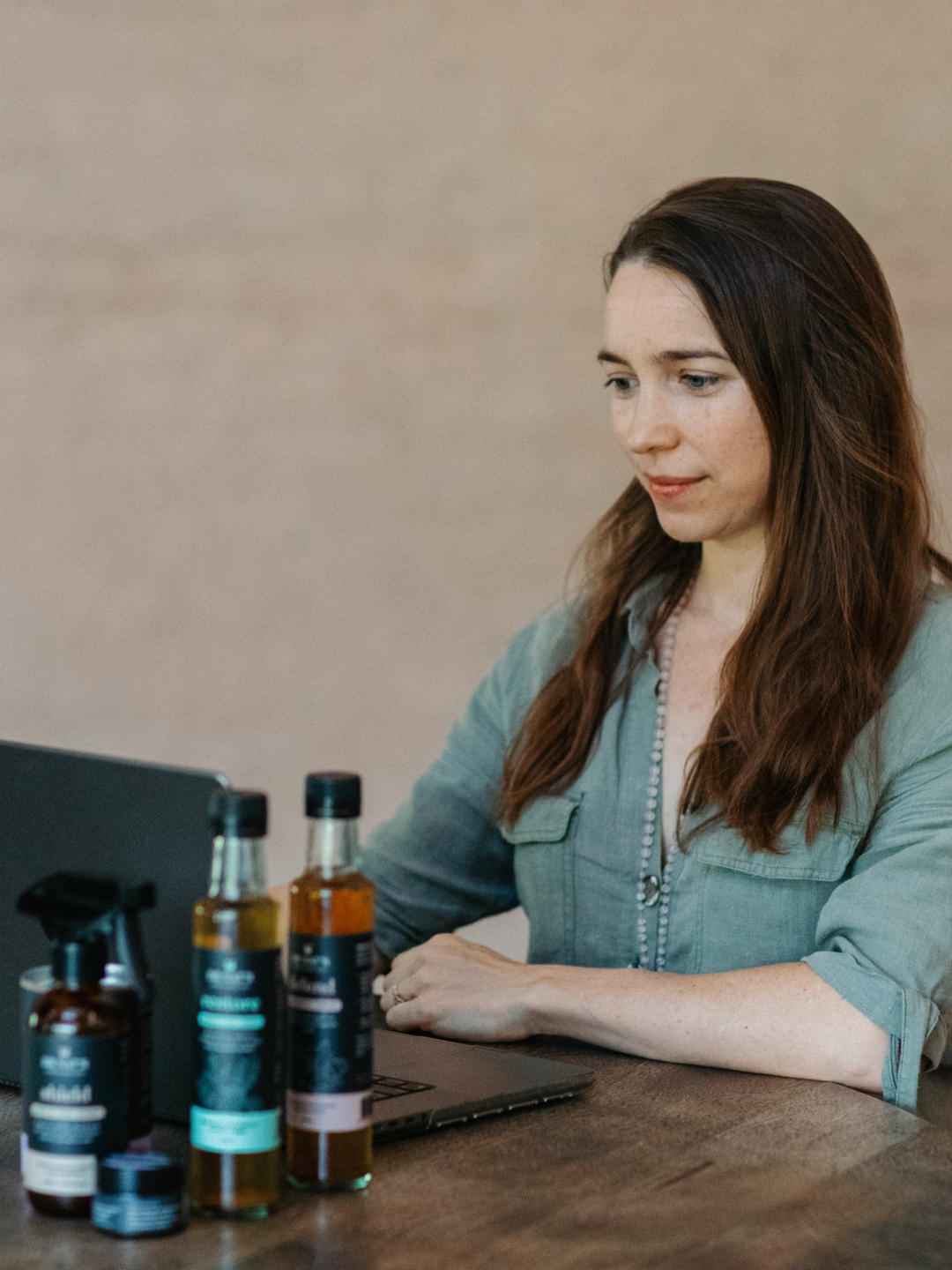 Dr Nat sits in front of a laptop, conducting a consultation, Ar Nats products are seen in the foreground.